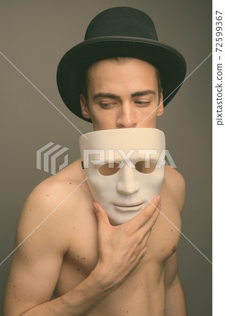Young handsome man shirtless against gray background Young handsome man shirtless against gray background 72599367