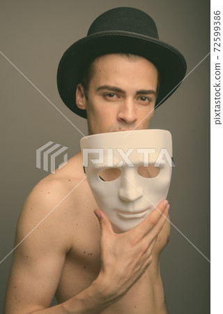 Young handsome man shirtless against gray background Young handsome man shirtless against gray background 72599386