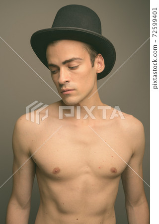 Young handsome man shirtless against gray background Young handsome man shirtless against gray background 72599401