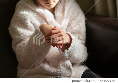 Girl caring for rough hands with alcohol disinfection 72599578