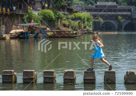 Young Caucasian girl on stepping stones in Fenghuang Young Caucasian girl on stepping stones in Fenghuang 72599990