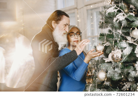 Senior couple with gifts near the Christmas tree 72601234