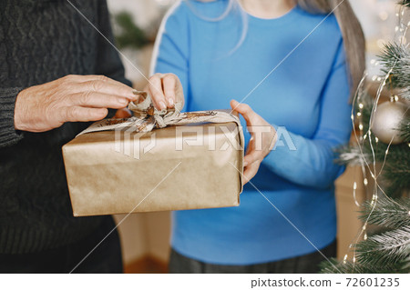 Senior couple with gifts near the Christmas tree 72601235