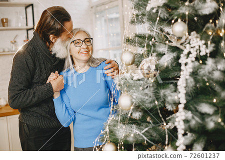 Senior couple with gifts near the Christmas tree Senior couple with gifts near the Christmas tree 72601237