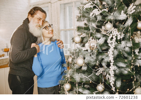 Senior couple with gifts near the Christmas tree Senior couple with gifts near the Christmas tree 72601238