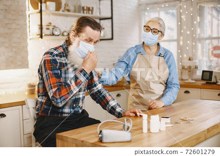 Senior woman and man at home meassure blood pressure 72601279