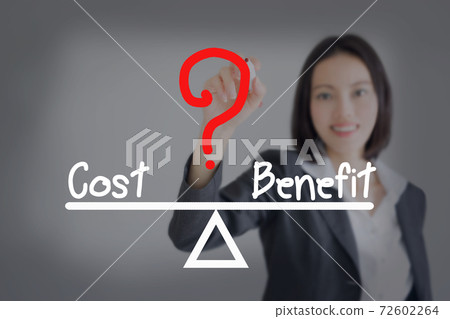 businesswoman writing cost and benefit compare on balance bar businesswoman writing cost and benefit compare on balance bar 72602264