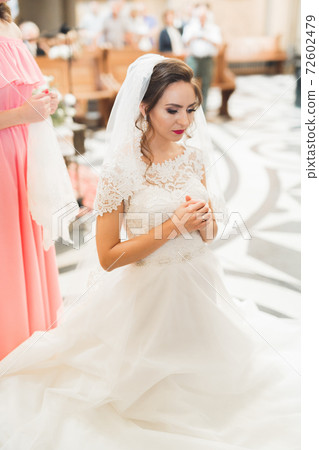 Married couple posing in a church after ceremony Married couple posing in a church after ceremony 72602479