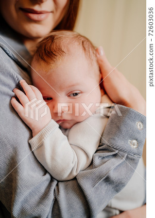 Mom gently holds on her kid in arm. long-awaited baby. Mother's Day. 72603036