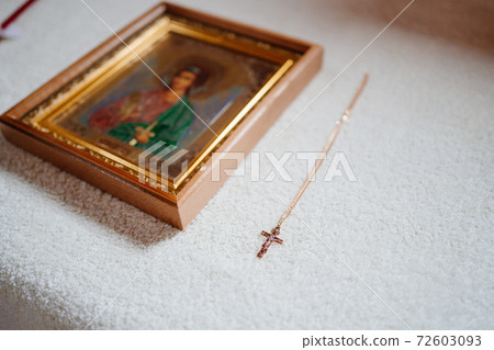 golden cross on the chain and Christian icon. Orthodox baptism. golden cross on the chain and Christian icon. Orthodox baptism. 72603093