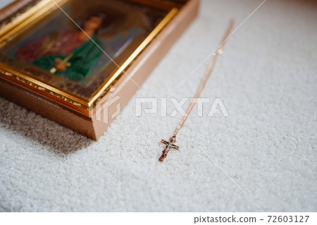 golden cross on the chain and Christian icon. Orthodox baptism. golden cross on the chain and Christian icon. Orthodox baptism. 72603127