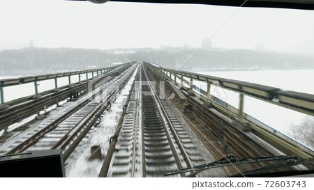 Train moves on the bridge across the river. 72603743