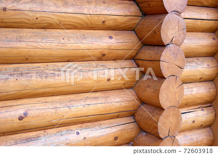 Corner of an old wooden house with round logs. Corner of an old wooden house with round logs. 72603918