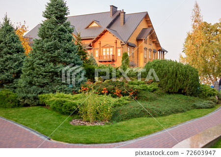 Big wooden luxury house with well-groomed garden. Big wooden luxury house with well-groomed garden. 72603947