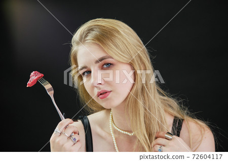 Portrait of a young sexy girl holding fork with raw meat piece. 72604117