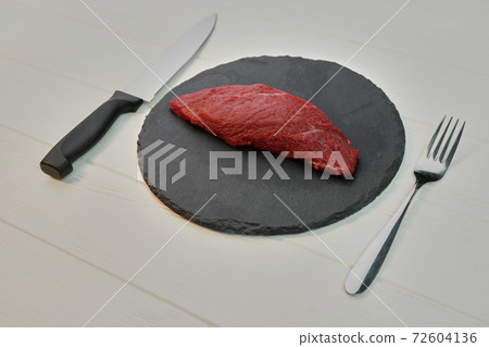 Raw uncooked fillet steak on a plate. Raw uncooked fillet steak on a plate. 72604136