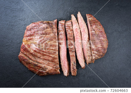 Traditional barbecue dry aged wagyu flank steak sliced and offered Traditional barbecue dry aged wagyu flank steak sliced and offered 72604663