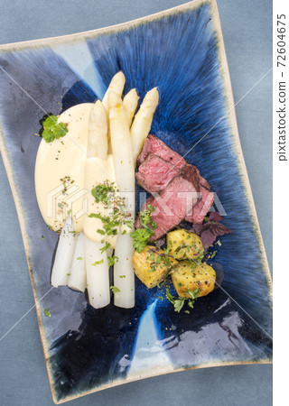 barbecue dry aged sliced fillet steak with white asparagus in hollandaise sauce barbecue dry aged sliced fillet steak with white asparagus in hollandaise sauce 72604675