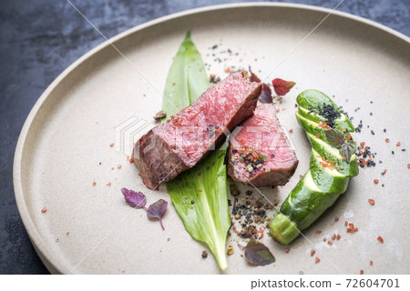 Modern style barbecue dry aged sliced fillet steak with wild garlic and zucchini Modern style barbecue dry aged sliced fillet steak with wild garlic and zucchini 72604701