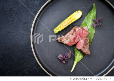 Traditional barbecue dry aged sliced filet steak with wild garlic Traditional barbecue dry aged sliced filet steak with wild garlic 72604702