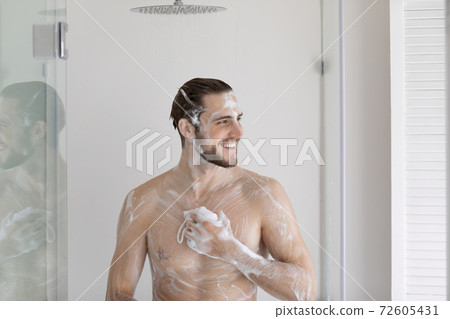 Happy young caucasian man taking shower in morning. 72605431