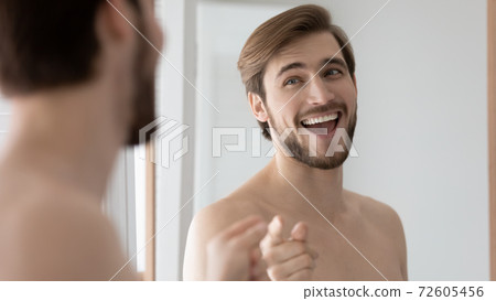 Overjoyed young handsome 30s man setting positive mood in bathroom. 72605456
