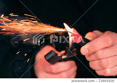Firecracker Burning in Hand with Sparks and Smoke 72605926