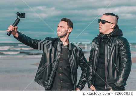 Two Handsome Guys Making Selfie Using Action Camera Two Handsome Guys Making Selfie Using Action Camera 72605928