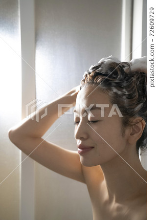 Woman doing hair care in the bathroom Woman doing hair care in the bathroom 72609729