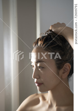 Woman doing hair care in the bathroom Woman doing hair care in the bathroom 72609791