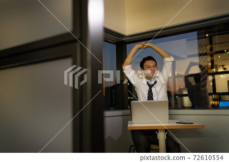 A businessman who works overtime late at night in the office A businessman who works overtime late at night in the office 72610554