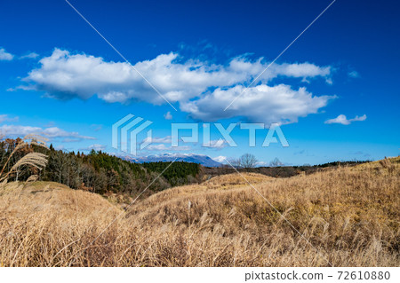 Snow piles up on the Kuju mountain range in winter on a clear day 72610880