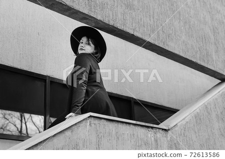 Brunette woman in hat on the stairs of building in city. Plus size model Brunette woman in hat on the stairs of building in city. Plus size model 72613586