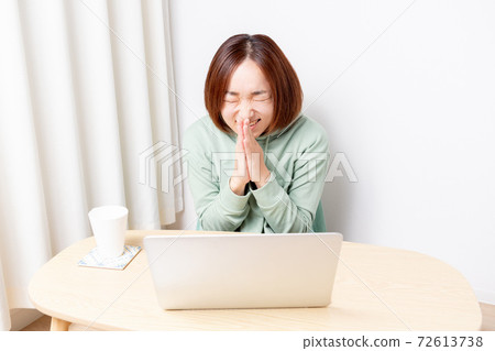 一個女人在使用便攜式計算機時做出請求的手勢 一個女人在使用便攜式計算機時做出請求的手勢 72613738