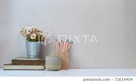 Designer workspace with pencils notebook, coffee cup,vase and copy space on white table. Designer workspace with pencils notebook, coffee cup,vase and copy space on white table. 72614404