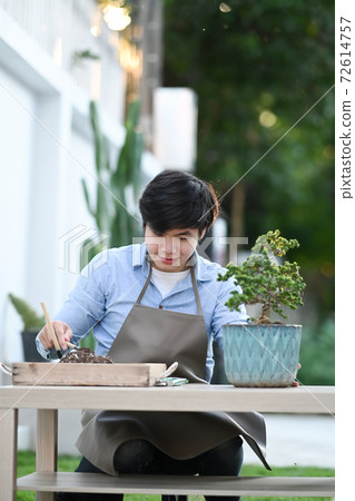 Portrait of young man taking care of plants as a hobby of home. 72614757