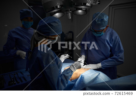 Doctors performing plastic surgery in operating room. Doctors performing plastic surgery in operating room. 72615469