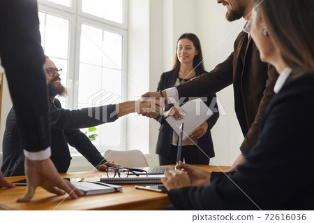 Business people making a deal and shaking hands after a negotiation meeting in the office 72616036