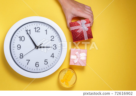Time to gift, shopping concept, clock and christmas gift boxes on a yellow background. flat lay 72616902