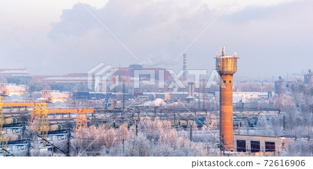 old brick water tower in winter on the background of factories and trees in the snow old brick water tower in winter on the background of factories and trees in the snow 72616906