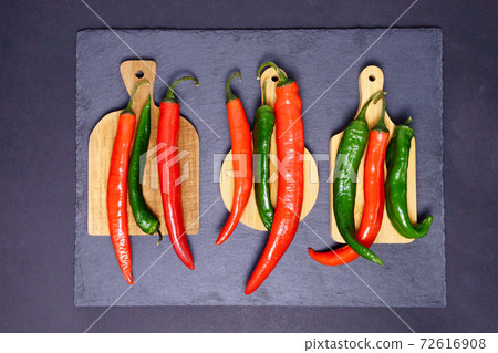 Red and green hot chili peppers with black background. flat lay Red and green hot chili peppers with black background. flat lay 72616908