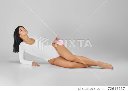 woman with gorgeous slim body holding pink pion flower woman with gorgeous slim body holding pink pion flower 72618237