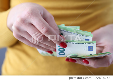 Woman holding lot of euro cash in her hands closeup 72618238