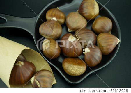 Fresh roasted chestnuts in their skins 72618938