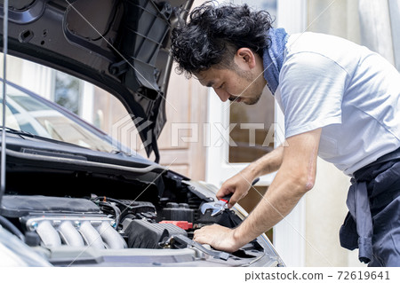 Man servicing a car Man servicing a car 72619641