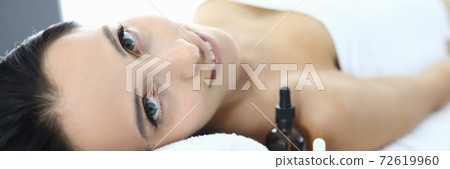 Portrait of smiling woman on massage table in spa center. Portrait of smiling woman on massage table in spa center. 72619960