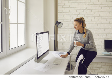 Company employee looking at screen of office computer and studying search results 72620733