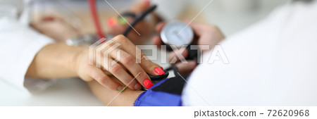 Doctor's female hand measures blood pressure to patient. Doctor's female hand measures blood pressure to patient. 72620968