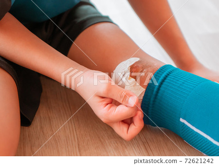 Little sporty football boy is opening his knee wound from accident in soccer match. Little sporty football boy is opening his knee wound from accident in soccer match. 72621242