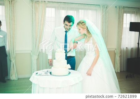 Bride and groom at wedding cutting the wedding cake 72621899